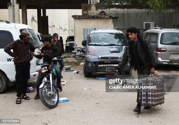 Syrian civilians and rebel fighters arrive in the village Mizanz, some 30 kilometres northeast of Idlib, on March 24 after being evacuated from...