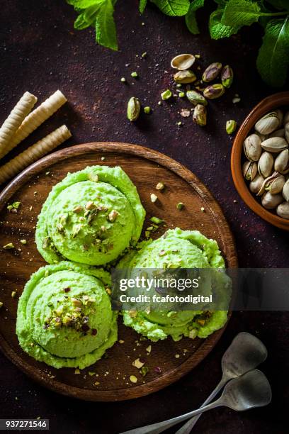 pistachio ice cream on rustic table - pistachio ice cream stock pictures, royalty-free photos & images