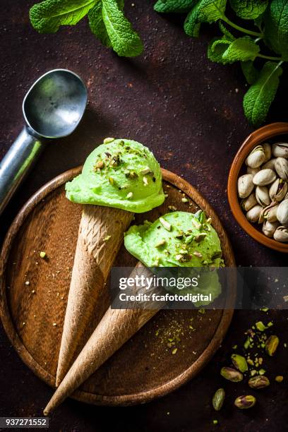 conos de helado de pistacho en mesa rústica - gelato fotografías e imágenes de stock