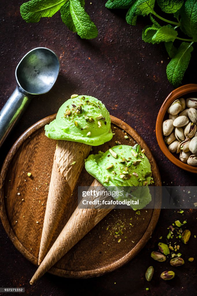 Pistachio ice cream cones shot on rustic table