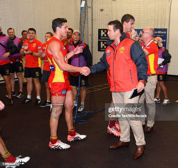 Suns coach Stuart Dew congratulates players after winning the round one AFL match between the Gold Coast Suns and the North Melbourne Kangaroos at...