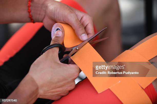 Yan Meng of Hengxiang Cycling Team China cuts kinesio tapes during Stage 7 of the Le Tour de Langkawi 2018, Nilai-Muar 222.4 km on March 24, 2018 in...
