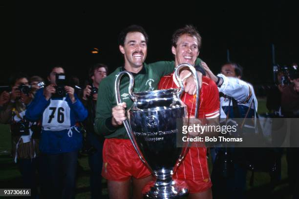 Liverpool goalkeeper Bruce Grobbelaar and teammate Phil Neal celebrate with the European Cup after Liverpool beat Roma 4-2 on penalties in the...