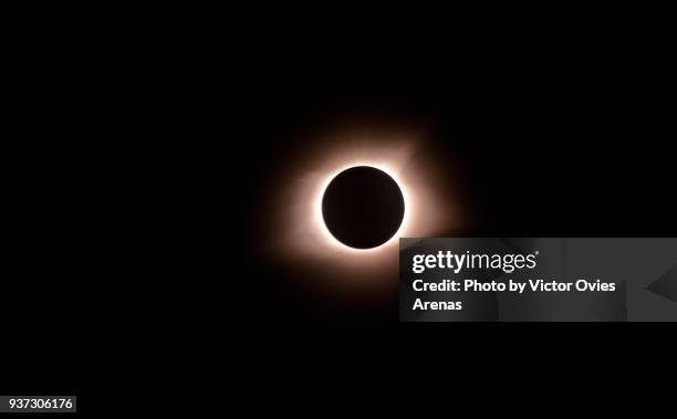 total eclipse of sun. sun's corona visible at the midpoint of time of totality or maximum point of the eclipse - glowing circle stock pictures, royalty-free photos & images