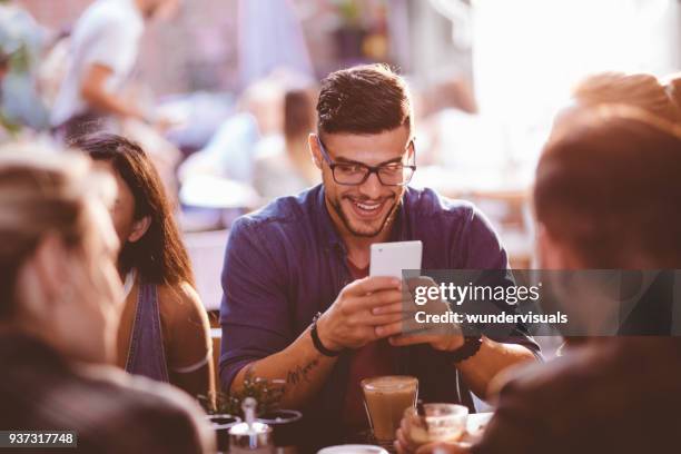 hombre feliz hipster en cafetería de mensajes de texto en el teléfono móvil - amigos hombres en restaurant fotografías e imágenes de stock