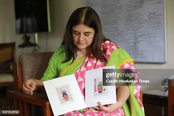 Union Minister for Women and Child Development Maneka Gandhi shows two of the mica miniature paintings from her collection, which she is selling to...