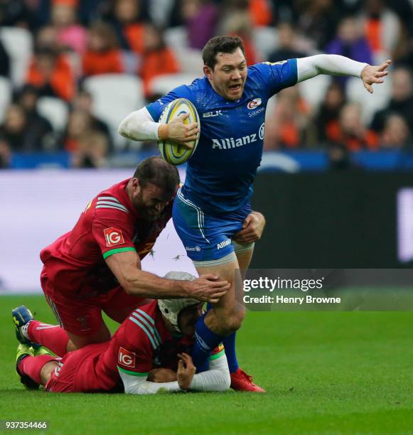 Alex Goode of Saracens tackled by Jamie Roberts and Demetri Catrakilis of Harlequins during the Aviva Premiership match between Saracens and...