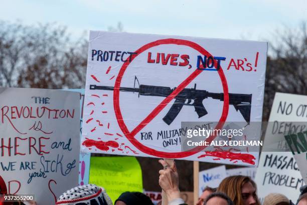 Rally goers carry protest signs during the March for Our Lives Rally in Washington, DC on March 24, 2018. - Galvanized by a massacre at a Florida...