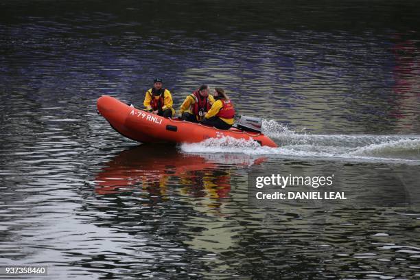 Personel patrol prior to the annual women's and men's boat races between Oxford University and Cambridge University, on the River Thames in London on...