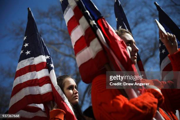 High school students from New Jersey hold American flags as they attend the March For Our Lives just north of Columbus Circle, March 24, 2018 in New...