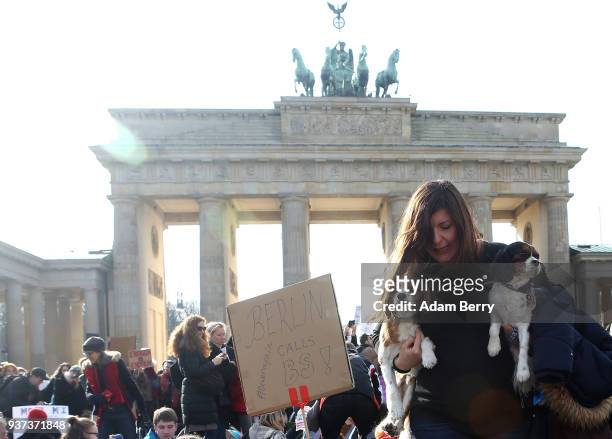 Participant carries dogs through the crowd in front of the Brandenburg Gate at the March for our Lives demonstration on March 24, 2018 in Berlin,...