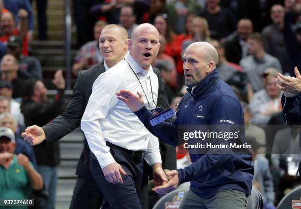 Assistant coach Jake Varner, head coach Cael Sanderson and assistant coach Casey Cunningham of the Penn State Nittany Lions celebrate after Bo Nickal...