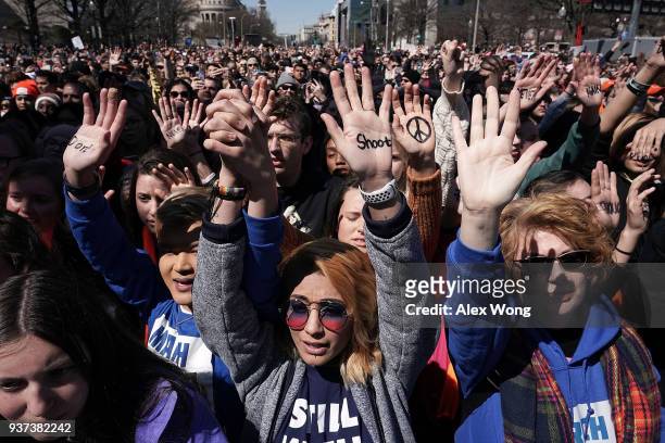 Protesters, including Daisy Hernandez of Virginia and Hunter Nguyen of Maryland , hold their hands up as they participate in the March for Our Lives...