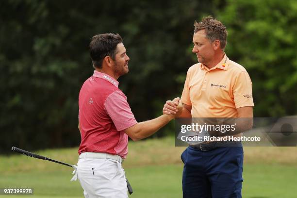 Ian Poulter of England shakes hands with Louis Oosthuizen of South Africa after defeating him 2&1 on the 17th green during the fourth round of the...