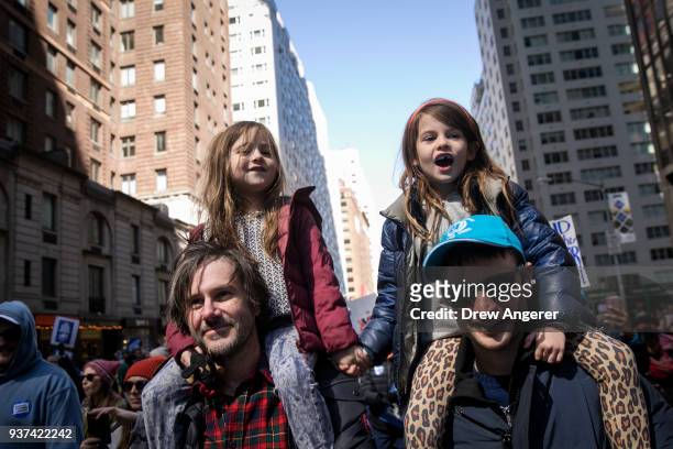 Henrietta Hamilton and Marlowe Sturridge ride on their fathers' shoulders as they march on Sixth Avenue during the March For Our Lives, March 24,...