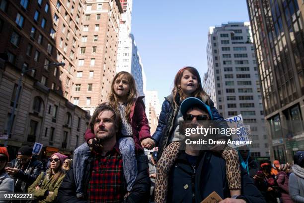 Henrietta Hamilton and Marlowe Sturridge ride on their fathers' shoulders as they march on Sixth Avenue during the March For Our Lives, March 24,...