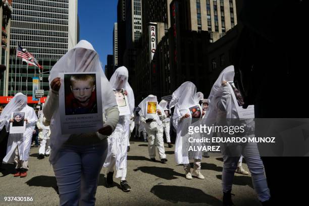 People carrying portraits of young victims of the Sandy Hook Elementary school massacre take part in the March for Our Lives Rally near Central Park...