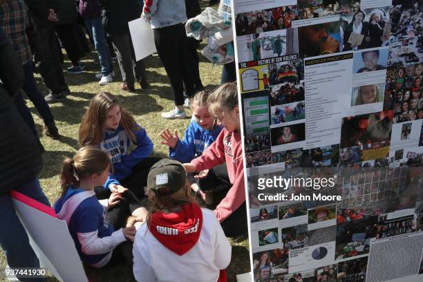 Children talk next to a display honoring people killed in school shootings during the March for Our Lives rally on March 24, 2018 in Stamford,...