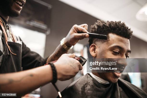 geben einen neuen haarschnitt in seinem geschäft barber - afro hairstyle stock-fotos und bilder