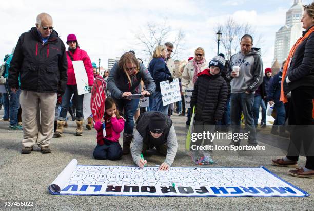Demonstrator signs a banner during the March For Our Lives Rally on March 24 at the Connecticut State Capitol in Hartford, CT.
