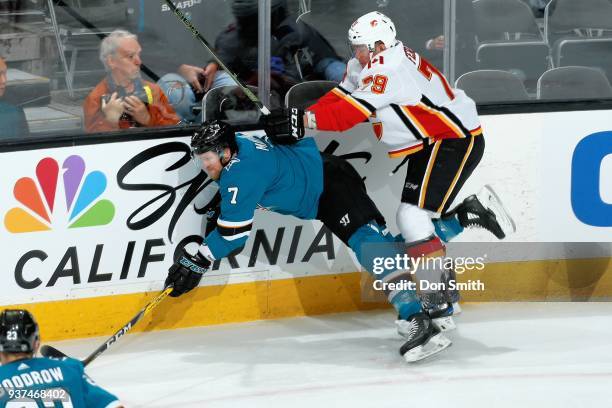 Paul Martin of the San Jose Sharks takes a hit from Michael Ferland of the Calgary Flames at SAP Center on March 24, 2018 in San Jose, California.