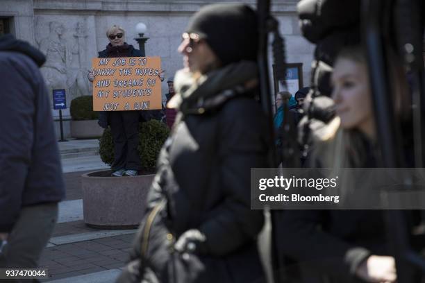 Demonstrators holds a sign that reads "My Job Is To Carry The Hopes And Dreams Of My Students Not A Gun," on Pennsylvania Avenue during the March For...