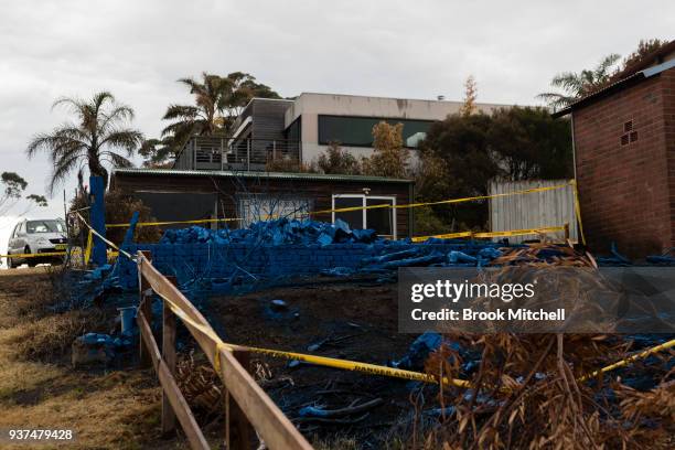 Home destroyed by fire is covered in blue asbestos retardent on March 25, 2018 in Tathra, Australia. A bushfire which started on 18 March destroyed...