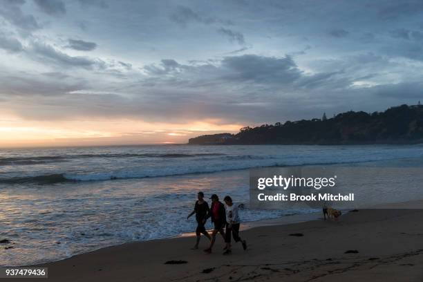 Residents on Tathra beach at sunrise on March 25, 2018 in Tathra, Australia. A bushfire which started on 18 March destroyed 65 houses, 35 caravans...