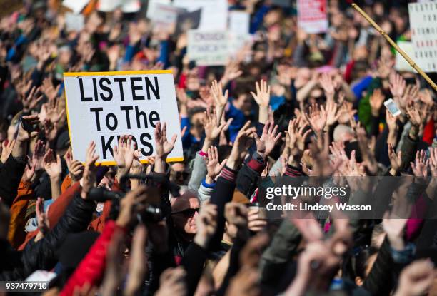 People hold their hands up as directed by musician Brandi Carlile at Seattle Center during the March for Our Lives rally on March 24, 2018 in...