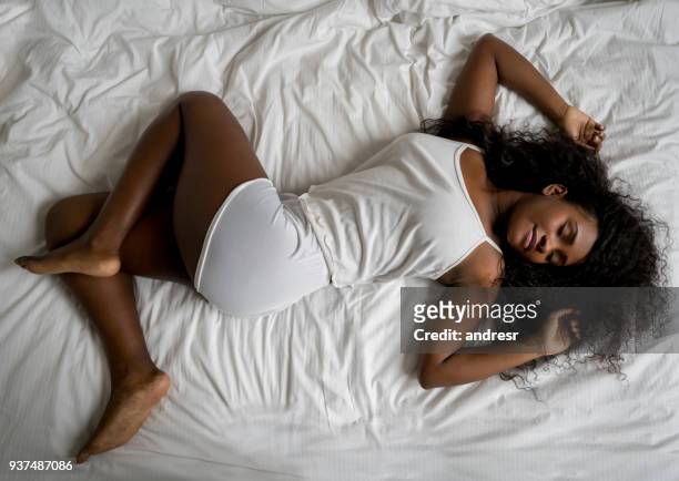 stunning latin american black woman sleeping very comfortable on her bed at home - african american woman pajamas residential building stock pictures, royalty-free photos & images