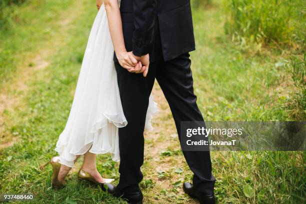 bride and groom holding hands with strong squeeze - jovanat stock pictures, royalty-free photos & images