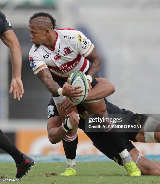 South Africa's Lions fly half Elton Jantjies is tackled by Argentina's Jaguares N8 Javier Ortega Desio during their Super Rugby match at Jose...