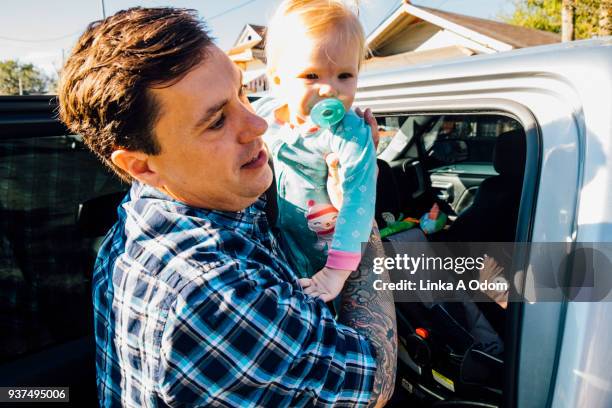 parent removing child from car - new orleans people stock pictures, royalty-free photos & images