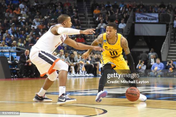 Jairus Lyles of the UMBC Retrievers dribbles around Devon Hall of the Virginia Cavaliers during the first round of the 2018 NCAA Men's Basketball...