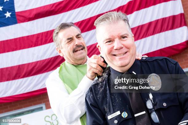 Los Angeles Police Chief Charlie Beck shaves the head of Los Angeles Police Department Lieutenant Greg Doyle at the St. Baldrick's Foundation...