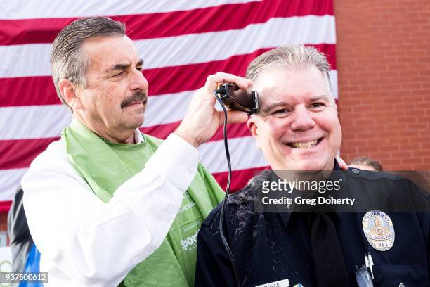 Los Angeles Police Chief Charlie Beck shaves the head of Los Angeles Police Department Lieutenant Greg Doyle at the St. Baldrick's Foundation...