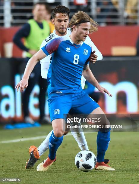 Birkir Bjarnason of Iceland vies for the ball with Diego Reyes of Mexico on March 23, 2018 in Santa Clara, California, during their international...