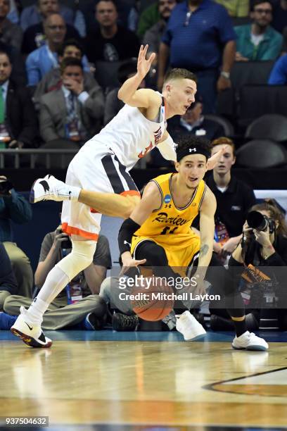 Maura of the UMBC Retrievers dribbles the ball by Kyle Guy of the Virginia Cavaliers during the first round of the 2018 NCAA Men's Basketball...