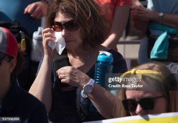 Laurie Teague of Littleton, Colorado, wipes a tear from her eye during the March for Our Lives rally on March 24, 2018 in Denver, Colorado. At right...