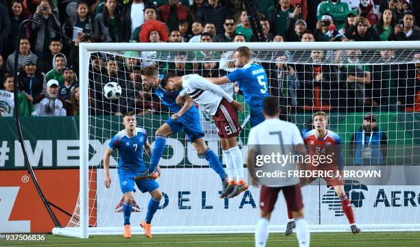 Diego Reyes of Mexico vies for the header with Kari Arnason and Sverrir Inge Ingason of Iceland on March 23, 2018 in Santa Clara, California, during...