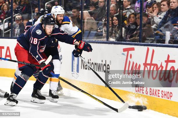 Pierre-Luc Dubois of the Columbus Blue Jackets and Robert Bortuzzo of the St. Louis Blues battle for a loose puck during the first period of a game...