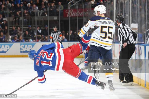 Rasmus Ristolainen of the Buffalo Sabres knocks down Peter Holland of the New York Rangers at Madison Square Garden on March 24, 2018 in New York...