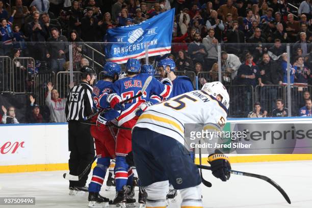 Rasmus Ristolainen of the Buffalo Sabres looks on as members of the New York Rangers celebrate a goal in the first period at Madison Square Garden on...