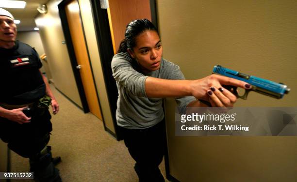Nicole Layog, former Broward County Sheriff Deputy, runs through a scenario in a "Lone Wolf" civilian active shooter response course for concealed...