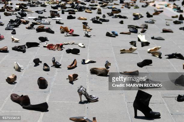 View of several shoes laid on the floor at a square as part of an installation called "My Feet are My wings" of Salvadorean artist Walterio Iraheta,...