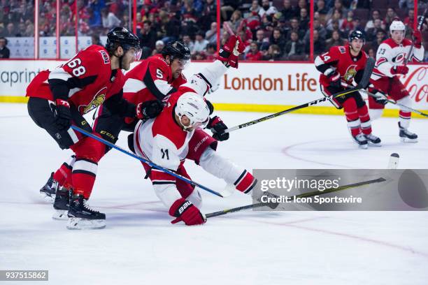 Ottawa Senators Defenceman Cody Ceci takes down Carolina Hurricanes Center Jordan Staal with the help of Ottawa Senators Right Wing Mike Hoffman...