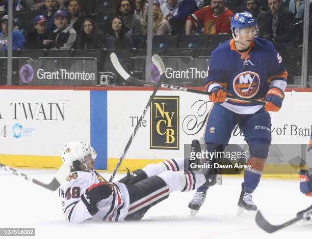 Tanner Fritz of the New York Islanders checks Vinnie Hinostroza of the Chicago Blackhawks during the first period at the Barclays Center on March 24,...