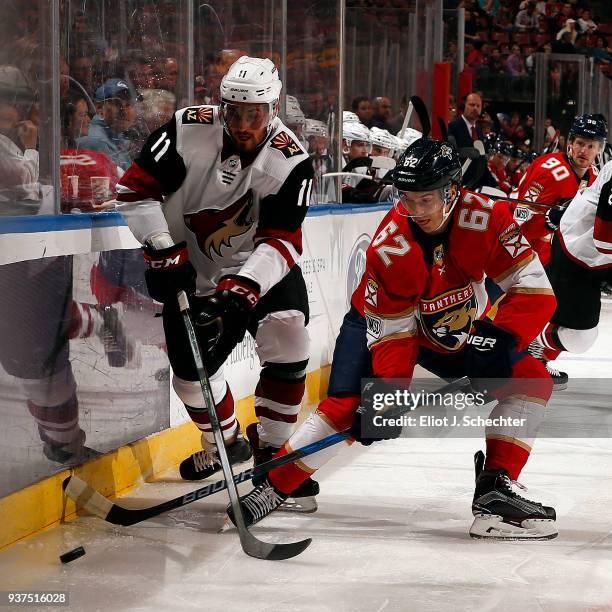 Brendan Perlini of the Arizona Coyotes crosses sticks with Denis Malgin of the Florida Panthers at the BB&T Center on March 24, 2018 in Sunrise,...