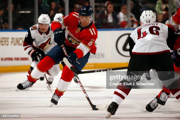 Jonathan Huberdeau of the Florida Panthers looks to pass the puck against Trevor Murphy of the Arizona Coyotes at the BB&T Center on March 24, 2018...