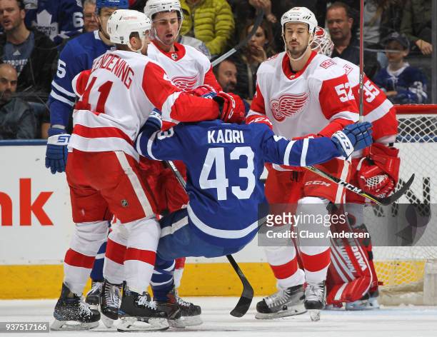 Luke Glendening of the Detroit Red Wings flattens Nazem Kadri of the Toronto Maple Leafs during an NHL game at the Air Canada Centre on March 24,...